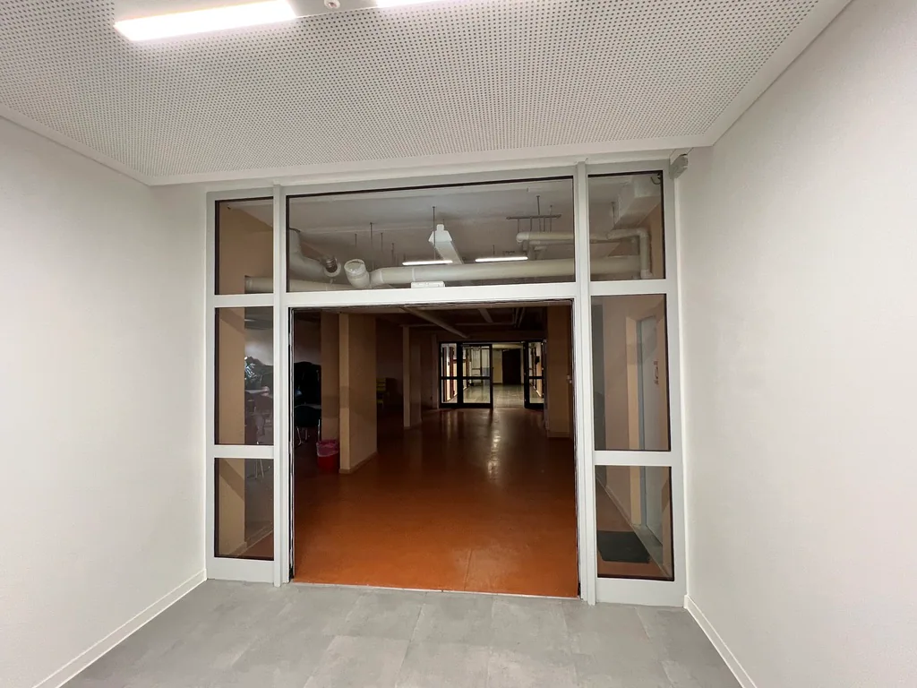 Heller Durchgang im Schulgebäude mit Akustikdecke und Bodenbelag