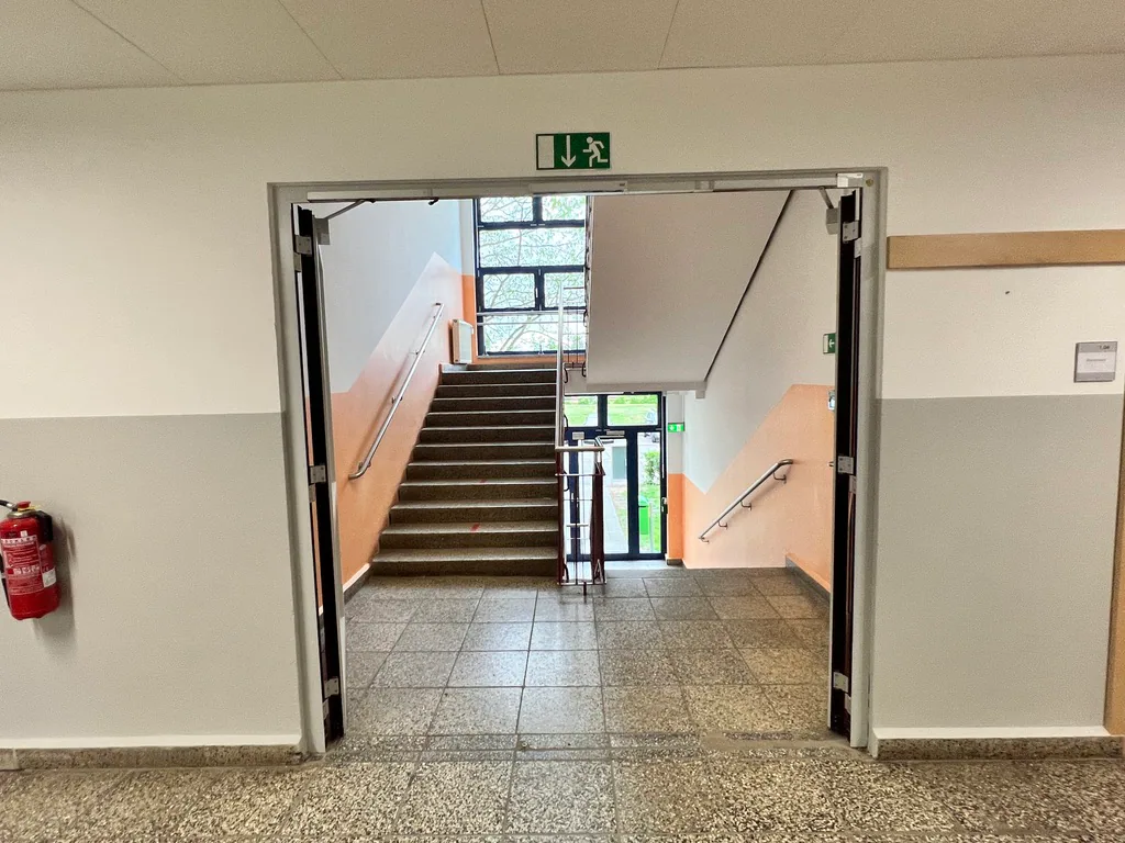 Treppenhaus im Schulgebäude mit zweifarbiger Wandgestaltung